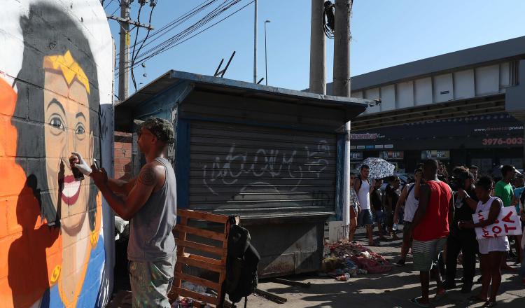 Un hombre pinta un grafiti del rostro de Marielle Franco en la favela carioca de Maré. EFE