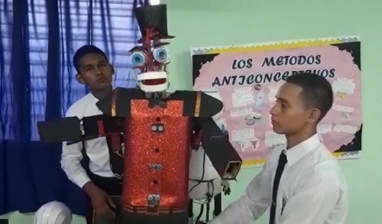 Los estudiantes Sudir Ojo (izq.) y Luis Castillo (der.) muestran el robot construido con piezas hechas con material reciclable. Elena Valdez.