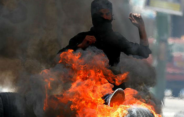 Palestinos bloquean una calle con neumático. Foto: EFE 