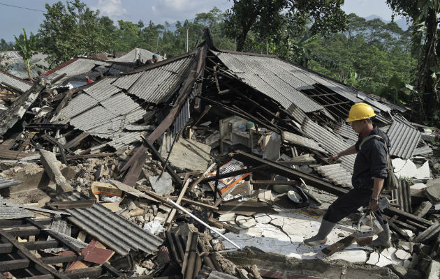 Un socorrista camina sobre los escombros de las casas. Foto: AP 