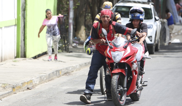 Los saqueadores se van con una motocicleta que acaban de sacar de una tienda en Managua. AP