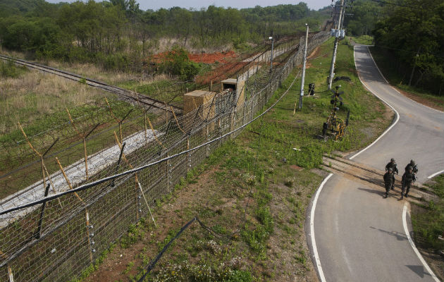 Soldados surcoreanos caminan sobre las vías del ferrocarril de Gyeongui, bloqueadas por una cerca de alambre de púas. FOTO/EFE