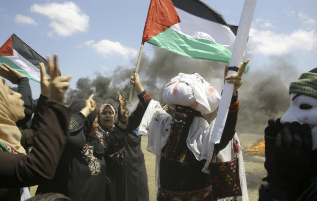 Mujeres palestinas agitan banderas nacionales y entonan consignas. Foto: AP