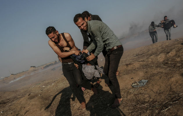 Una mujer herida, durante los enfrentamientos. Foto: EFE  