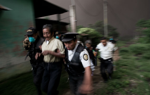Un grupo de policías de Guatemala evacúa a un hombre en la aldea El Porvenir (Guatemala).