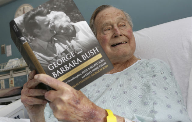 George H.W. Bush, disfruta del libro que cuenta su historia con la difunta Bárbara Bush. FOTO/AP