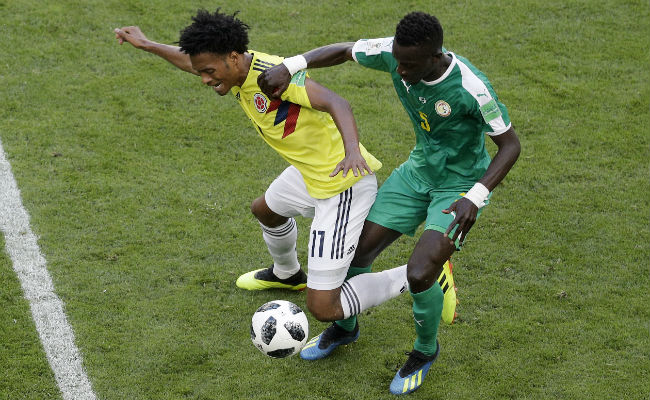 Juan Cuadrado de Colombia disputa un balón contra Idrissa Gana de Senegal. Foto:AP