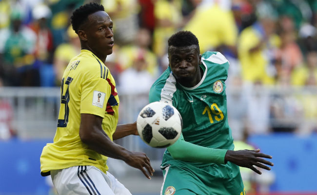 El colombiano Yerry Mina, (Izq.) disputa el balón contra Mbaye Niang de Nigeria. Foto:AP