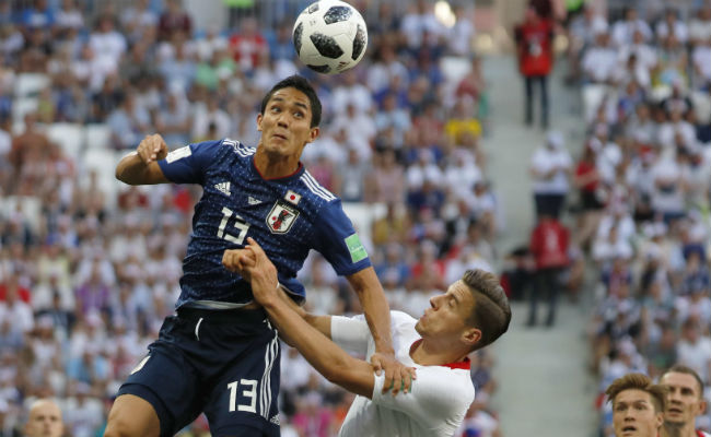 Jan Bednarek (der)  de Japón  salta a disputar el balón ante Yoshinori Muto  de Japón.Foto:AP