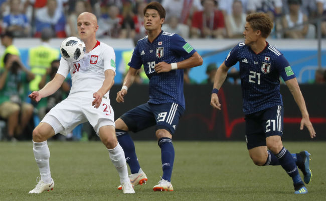 Rafal Kurzawa (izq.) de Polonia  y Hiroki Sakai (cent) de Japón disputan el balón. Foto:AP 