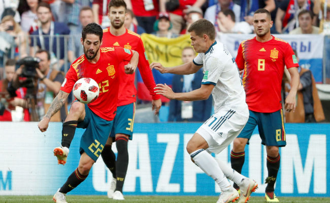 El centrocampista español Isco (Izp) y el ruso Roman Zobnin (der.) disputan en el balón. Foto:AP