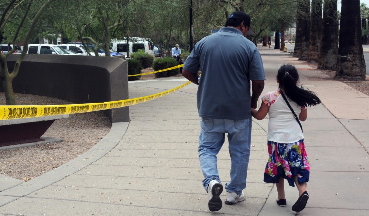 Un hombre camina junto a su hija tras salir de una cita del ICE. EFE