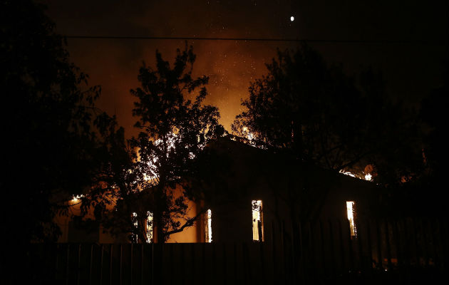 Una vivienda arde en llamas durante un incendio forestal en Mati, un suburbio al noreste de Atenas. FOTO/EFE