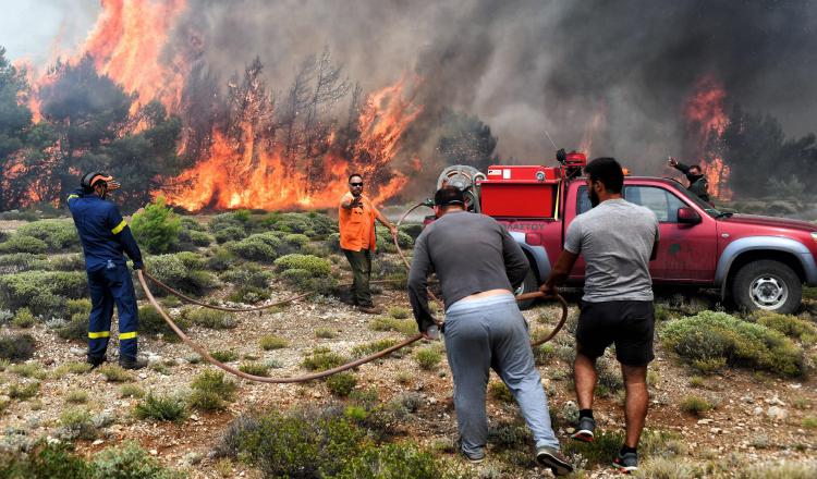 Varios bomberos y voluntarios luchan contra las llamas en un incendio en Verori, cerca de la ciudad de Loutraki (Grecia). EFE