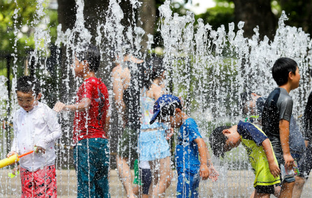 Varios niños juegan en los chorros de agua de una fuente en un parque cerca de Nerima. Foto: EFE 