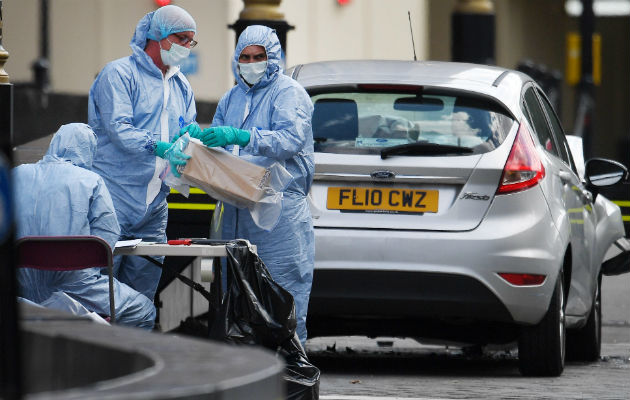 Oficiales forenses examinan el coche que chocó contra las barreras del Parlamento británico. Foto: EFE