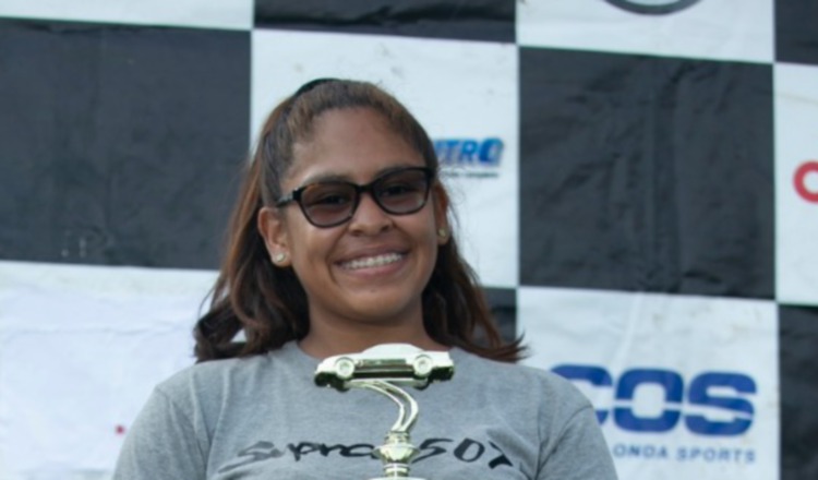 La piloto posa sonriente con su trofeo.