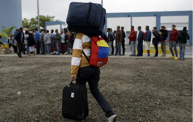 Venezolano camina hacia Perú con su equipaje. 