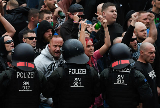 Manifestantes de derecha hacen gestos hacia la policía antidisturbios. Foto: EFE.