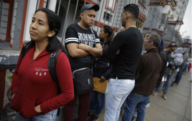 Migrantes venezolanos afuera de la embajada de su país en Lima, Perú. Foto: AP.