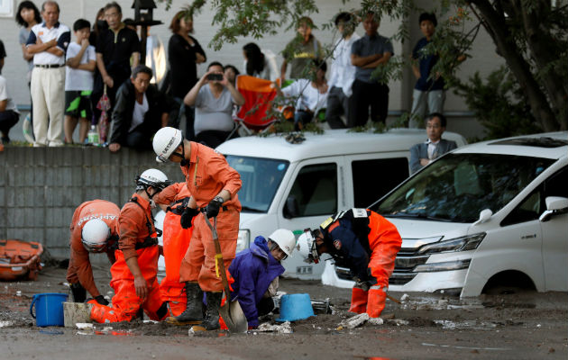 Una trabajadora de HTB (2-d) es rescatada por los servicios de emergencias tras verse atrapada en el lodo por el terremoto en Japón. EFE