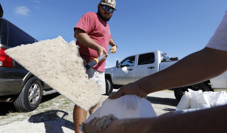 Un grupo de personas protegen sus casas ante la llegada del huracán Florence. AP