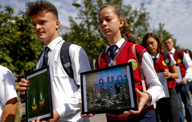 Estudiantes albanokosovares sostienen fotografías de las Torres Gemelas de Nueva York durante una marcha con motivo del 17 aniversario de los atentados de 2001, en Pristina, Kosovo, hoy, 11 de septiembre de 2018. EFE/ Valdrin Xhemaj