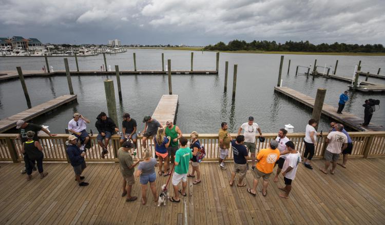 Un grupo de personas se reúne afuera del restaurante Dockside en lo que han denominado como 