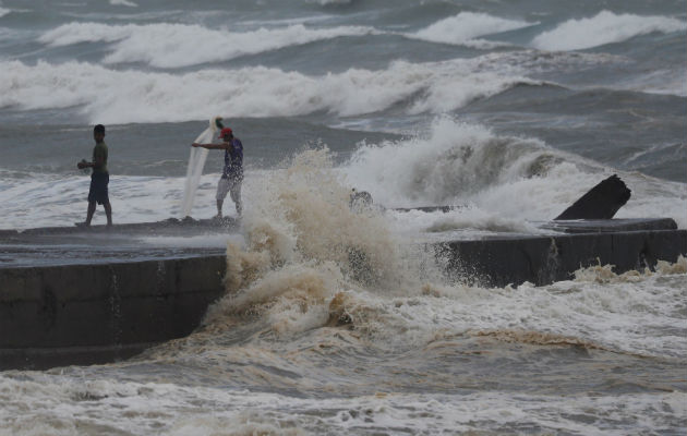 Hombres pescan en la orilla ante el peligro de las olas por llegada del tifón Mangkhut. Foto: EFE