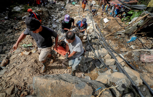 Filipinos cargan con el cuerpo de una víctima de un deslizamiento de tierra causado por el tifón Mangkhut en Filipinas. EFE