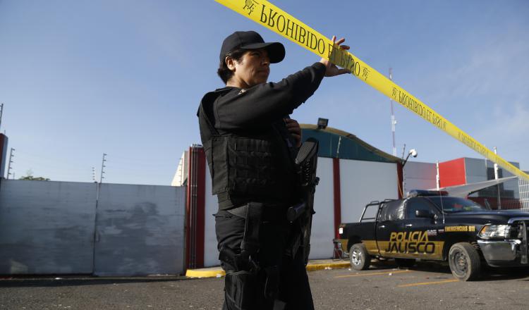 Un policía presta guardia en las inmediaciones del Instituto Jalisciense de Ciencias Forenses. EFE