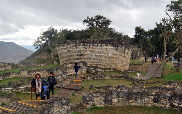 Turistas paseando ante la muralla de la prehispánica ciudad fortificada de Kuélap Se puede llegar en el primer teleférico instalado en Perú, un recorrido de cuatro kilómetros por un sobrecogedor paisaje.