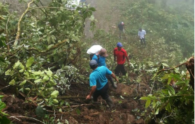 Moradores y docentes arriesgan sus vidas al cruzar en medio del alud de tierra. Foto: Mayra Madrid.