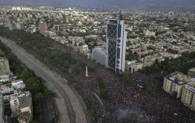  Encapuchados montan barricadas frente a la policía tras manifestarse en el centro de Santiago. Foto: EFE.