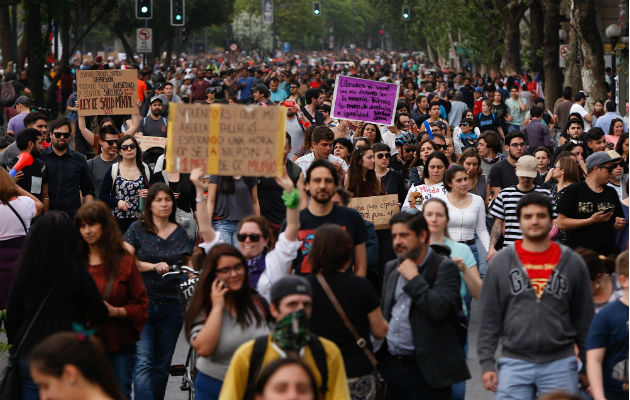  Encapuchados montan barricadas frente a la policía tras manifestarse en el centro de Santiago. Foto: EFE.