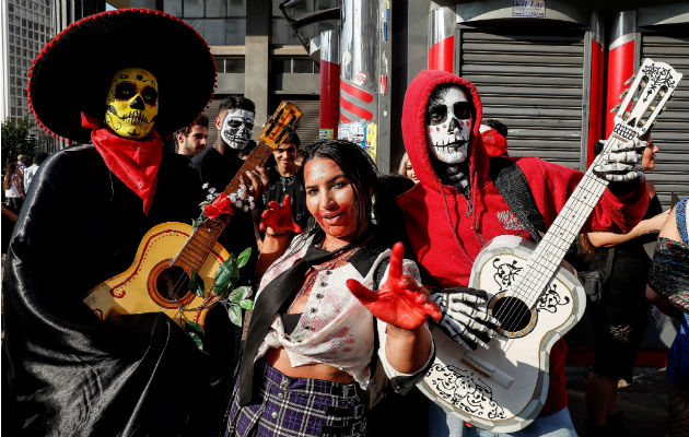 Indígenas comen sobre las tumbas en la celebración del Día de Muertos en Calpi, provincia de Chimborazo, Ecuador. Foto.EFE.