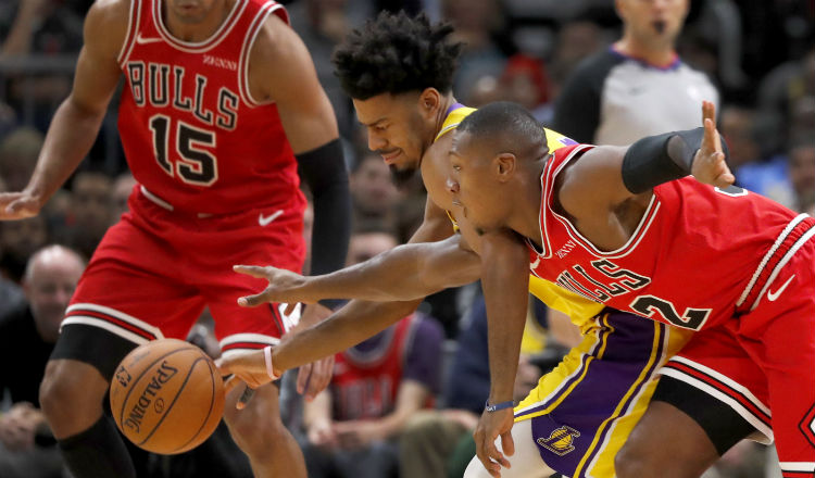 Quinn Cook, de los Lakers, disputa el balón con Kris Dunn. Foto AP