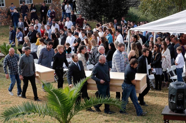 Los hombres llevan los ataúdes de Dawna Ray Langford, de 43 años, y sus hijos Trevor, de 11 años, y Rogan, de 2, que fueron asesinados por pistoleros del cartel de la droga, durante su funeral en el cementerio en La Mora.. FOTO/AP