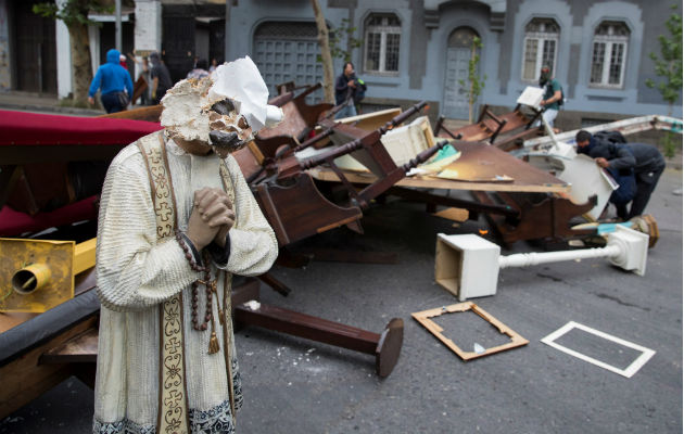 Manifestantes retiran objetos de la Parroquia de La Asunción, en la céntrica Plaza Italia, en Santiago (Chile). Foto: EFE.