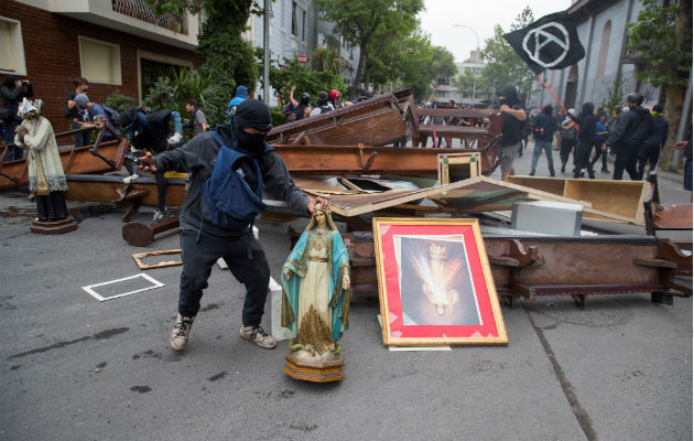 Manifestantes retiran objetos de la Parroquia de La Asunción, en la céntrica Plaza Italia, en Santiago (Chile). Foto: EFE.