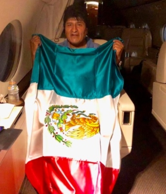 El expresidente de Bolivia Evo Morales posa con una bandera mexicana, durante su viaje en un avión de la Fuerza Aérea Mexicana.