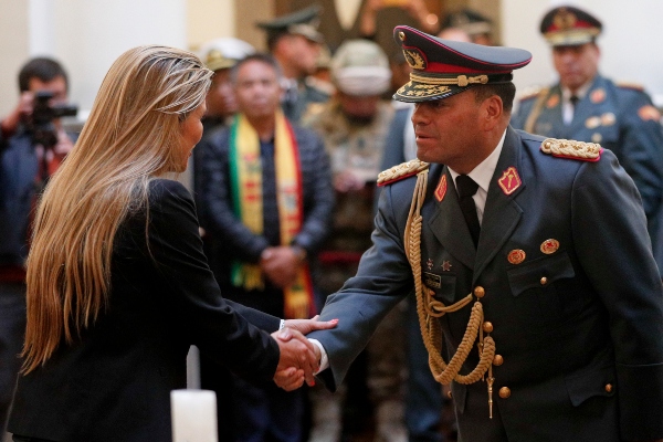 El comandante en jefe, Carlos Orellana Centellas (2i), saluda a la mandataria interina de Bolivia, Jeanine Áñez (i), durante la juramentación del nuevo Alto Cargo Militar este miércoles, en Palacio Quemado, en La Paz (Bolivia). FOTO/EFE