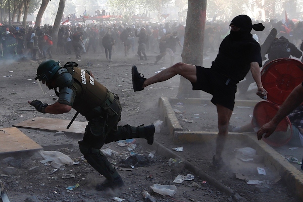 Un carabinero es agredido por uno de los manifestantes en Chile. FOTO/AP