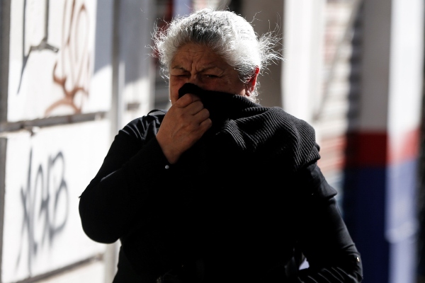  Transeúntes se protegen de los gases lacrimógenos durante manifestaciones en el centro de Santiago (Chile). Hemorragias nasales, conjuntivitis, dermatitis o tos aguda. FOTO/EFE