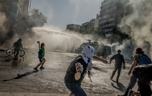 La clase media chilena lucha con precios altos y sueldos bajos. Un reciente choque con la Policía en Santiago. Foto/ Tomas Munita para The New York Times.