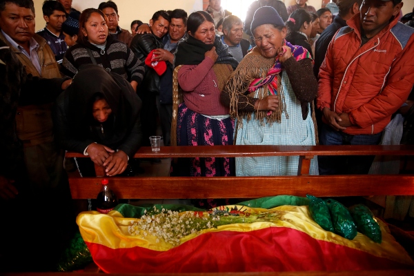 Familiares lloran junto al cuerpo de un hombre asesinado durante los enfrentamientos entre las fuerzas de seguridad y los partidarios del ex presidente Evo Morales. FOTO/AP