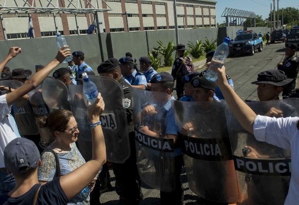 Católicos protestan en las afueras de un templo  contra la policía. EFE