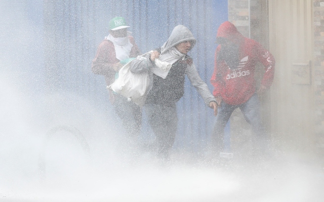  Tres personas llevan bolsas con elementos luego de ingresar a un local comercial saqueado durante las protestas, en un sector de Patio Bonito, sur de Bogotá. FOTO/EFE