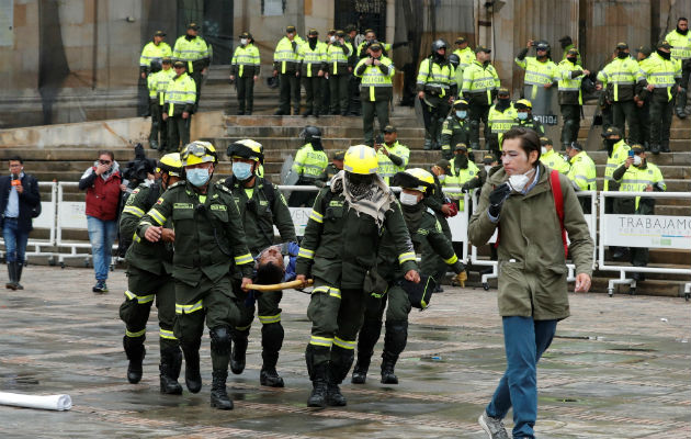 Equipos de emergencia atienden a un herido durante el cacerolazo en la Plaza Bolívar de Bogotá. Foto: EFE.