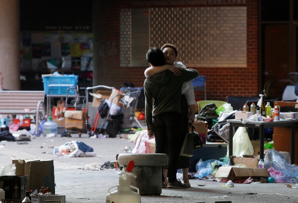 Un manifestante abraza a un trabajador social dentro del campus de la Universidad Politécnica de Hong Kong. La mayoría de los manifestantes que se hicieron cargo de la universidad la semana pasada se han ido, pero un número desconocido ha permanecido adentro durante días, esperando de alguna manera para evitar el arresto. FOTO/AP